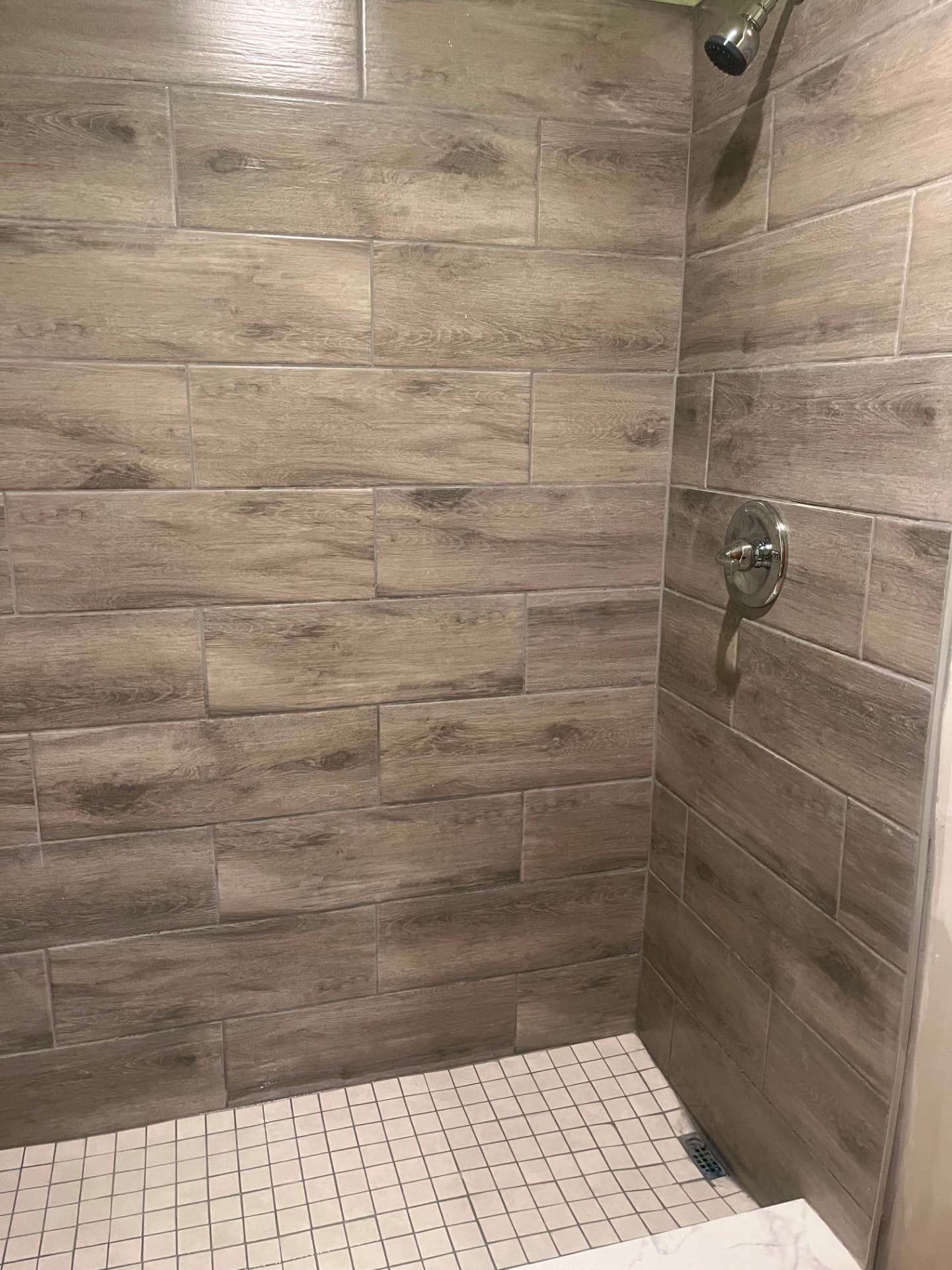 Wood-look tile shower surround with mosaic floor