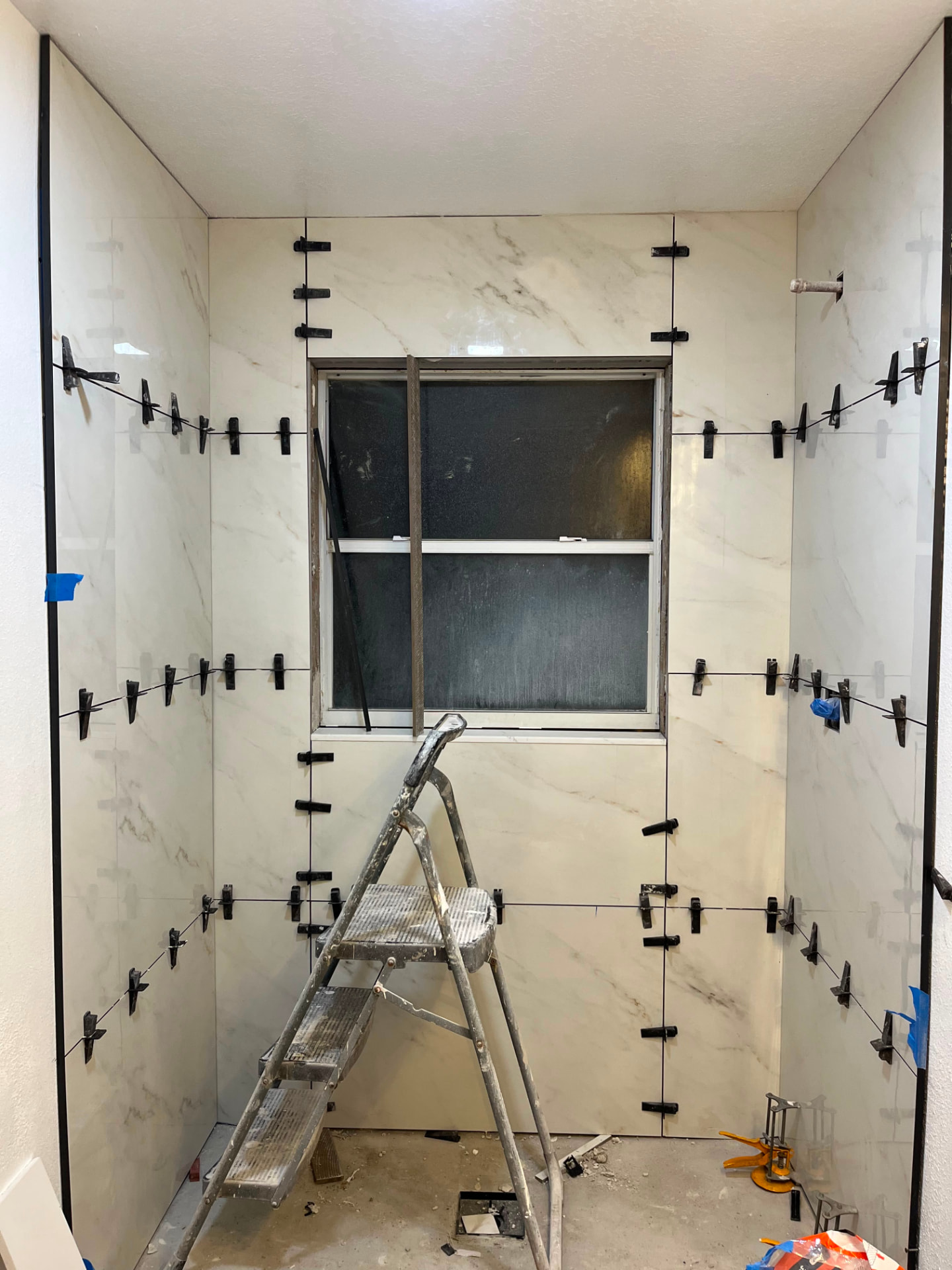 Large-format porcelain shower walls set with leveling clips